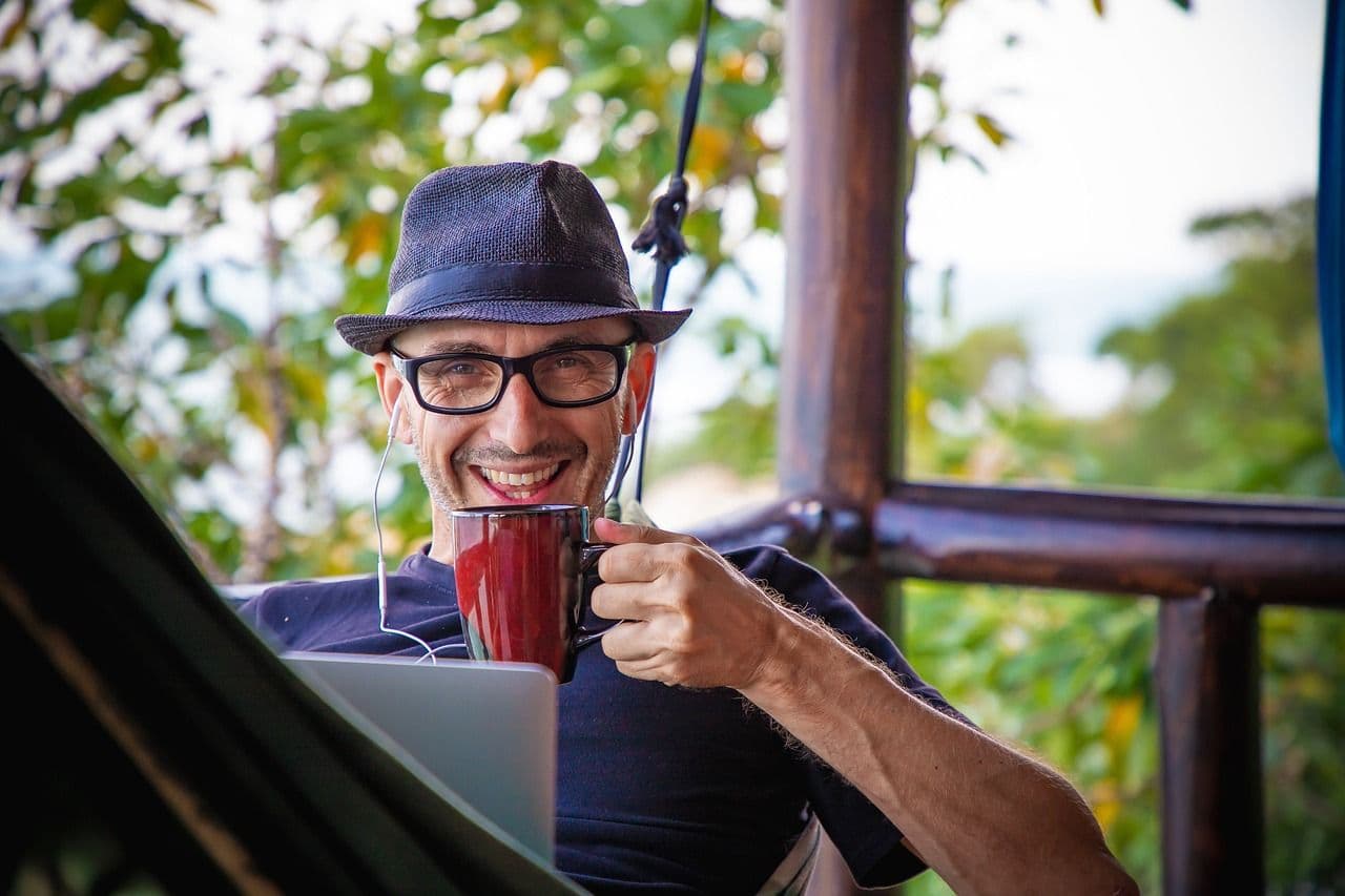 A digital nomad working with a laptop and drinking coffee